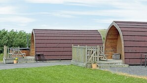 A row of wooden, curved-roofed cabins with wooden steps leading to the entrance. - 1 bedroom accommodation in Corney, near Millom (Corney, near Millom)