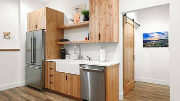 A modern kitchen with wooden cabinets, stainless steel appliances, and a white countertop.
