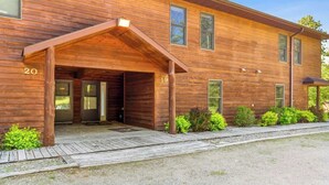 A wooden building with a covered entrance, numbered 19 and 20, and a gravel driveway. - Lakeside Condo #19 4BR 4BA Timberlane Resort (Park Rapids)