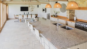 Una cocina moderna con encimera de granito, electrodomésticos de acero inoxidable e iluminación colgante.
