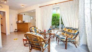 Amplia sala de estar con muebles de mimbre y vistas al exterior.