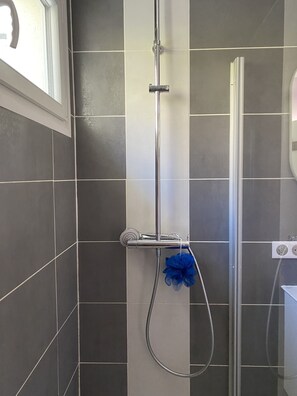 Enjoy a refreshing shower experience with a vertical showerhead and handheld attachment in a, modern space.