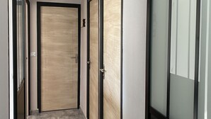 Un pasillo con tres puertas, cada una con un diseño y tiradores distintos.