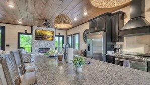 A modern kitchen with granite countertops, stainless steel appliances, and a large island. - Luxury Escape: Private Pool, Theatre & Waterpark • 6mi Dollywood • 1mi Parkway (Sevierville)