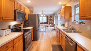 Una cocina moderna con armarios de madera, electrodomésticos de acero inoxidable y una isla central.