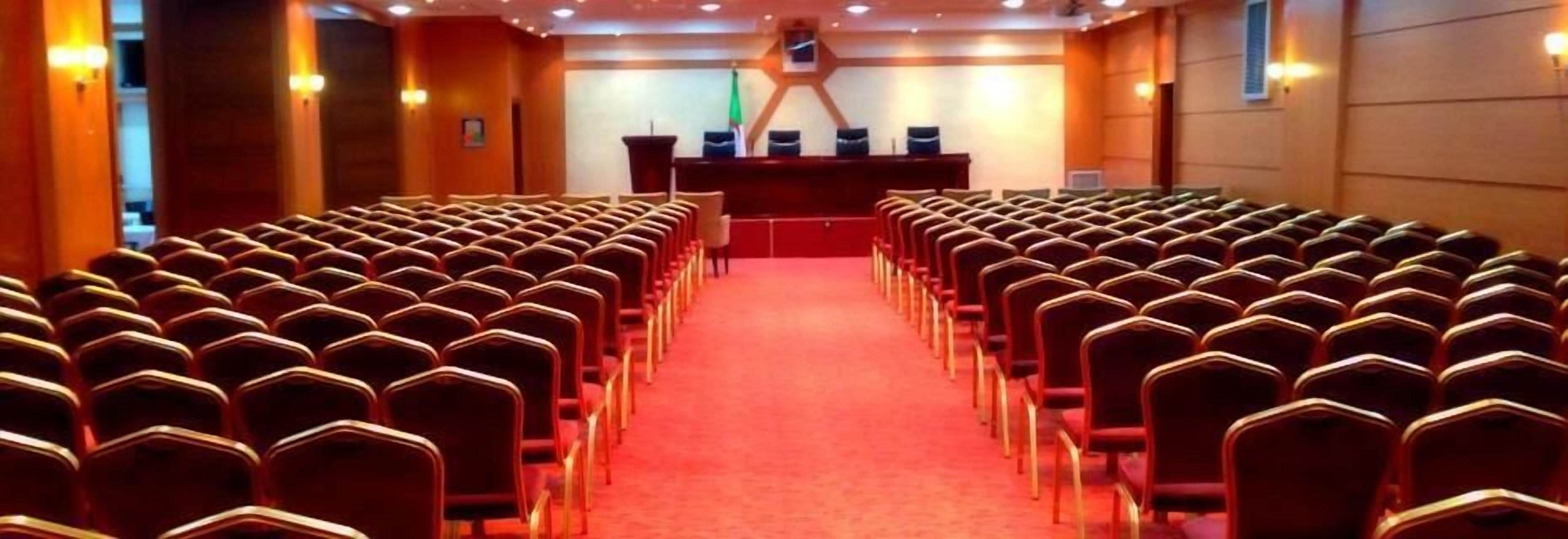 A conference room with rows of chairs facing a podium.