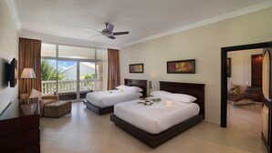 A hotel room with two beds, a ceiling fan, a balcony with curtains, and a view of the outdoors.