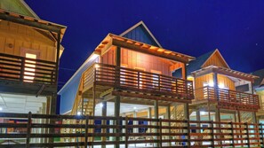 A wooden building with multiple levels, balconies, and a wooden fence.