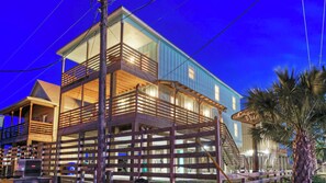 A multi-story wooden building with balconies and a sign that reads 'Lagniappe Village.'