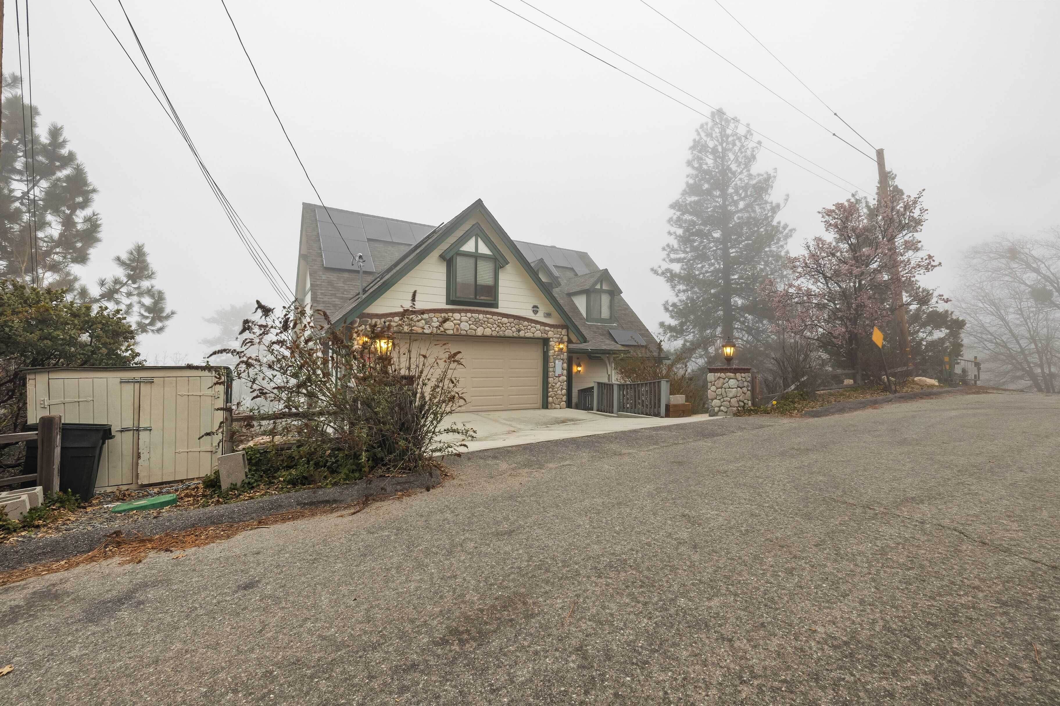 A house with a garage, a stone entrance, and a driveway.