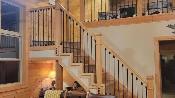A wooden interior with a staircase, two leather chairs, and a small table. - Brand New Luxury Cabin 5 minutes to TIEC
 (Tryon)