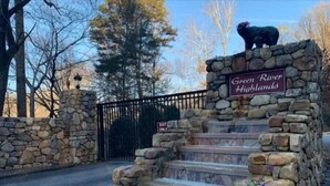 A stone staircase leading to a small waterfall, with a sign reading "Green River Highlands." - Brand New Luxury Cabin 5 minutes to TIEC
 (Tryon)
