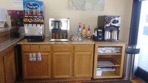 A kitchen with a coffee machine, a water dispenser, and a coffee maker.