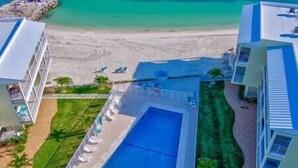 An aerial view of a resort with a swimming pool, beach access, and multiple buildings. - Ocean Oasis!OceanView-Beach/Pool (Key Colony Beach)