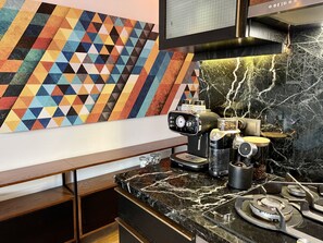 A modern kitchen with a marble countertop, a coffee machine, and a geometric-patterned wall art. - Your second home w/stunning view (Istanbul)