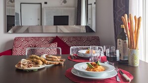 Une table à manger avec des assiettes remplies de nourriture, des verres et une bouteille d’huile d’olive.