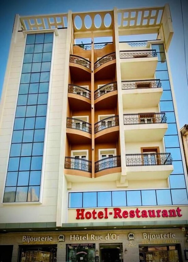 A hotel with a central atrium, balconies, and a sign indicating it is a hotel and restaurant.
