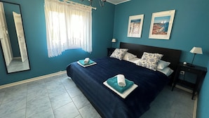 A bedroom with a large bed, two nightstands, a chandelier, a window with curtains, and two framed pictures on the wall. - Apartment 3, Apartment mit Meerblick (Vodice)