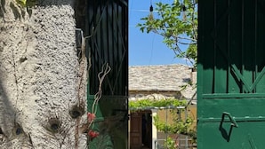 Ein rustikaler Hauseingang mit einer grünen Tür und einem Schild mit der Aufschrift 'House No. 22'.