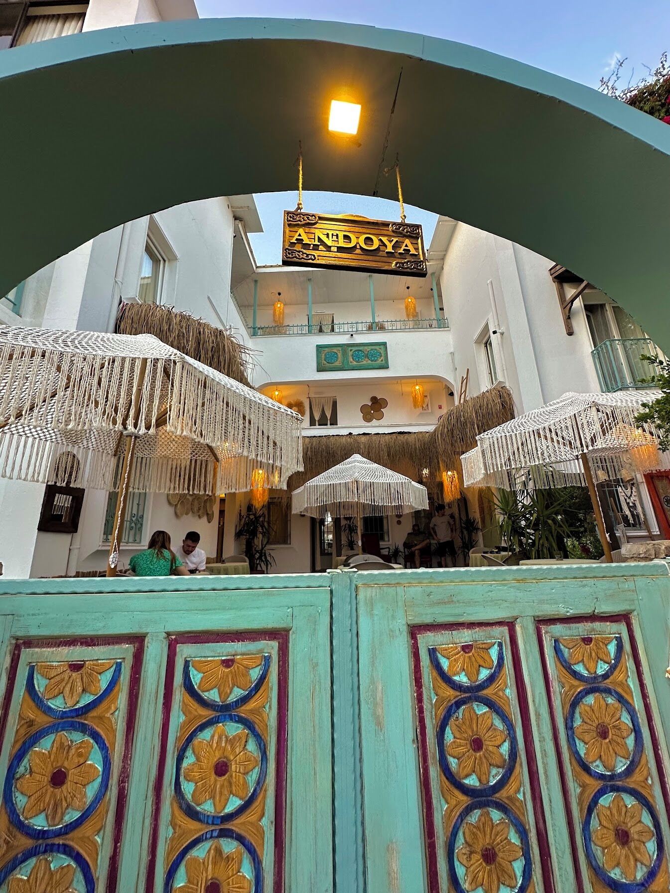 A building entrance with a sign reading 'ANDOYYA' and a decorative archway with floral patterns.