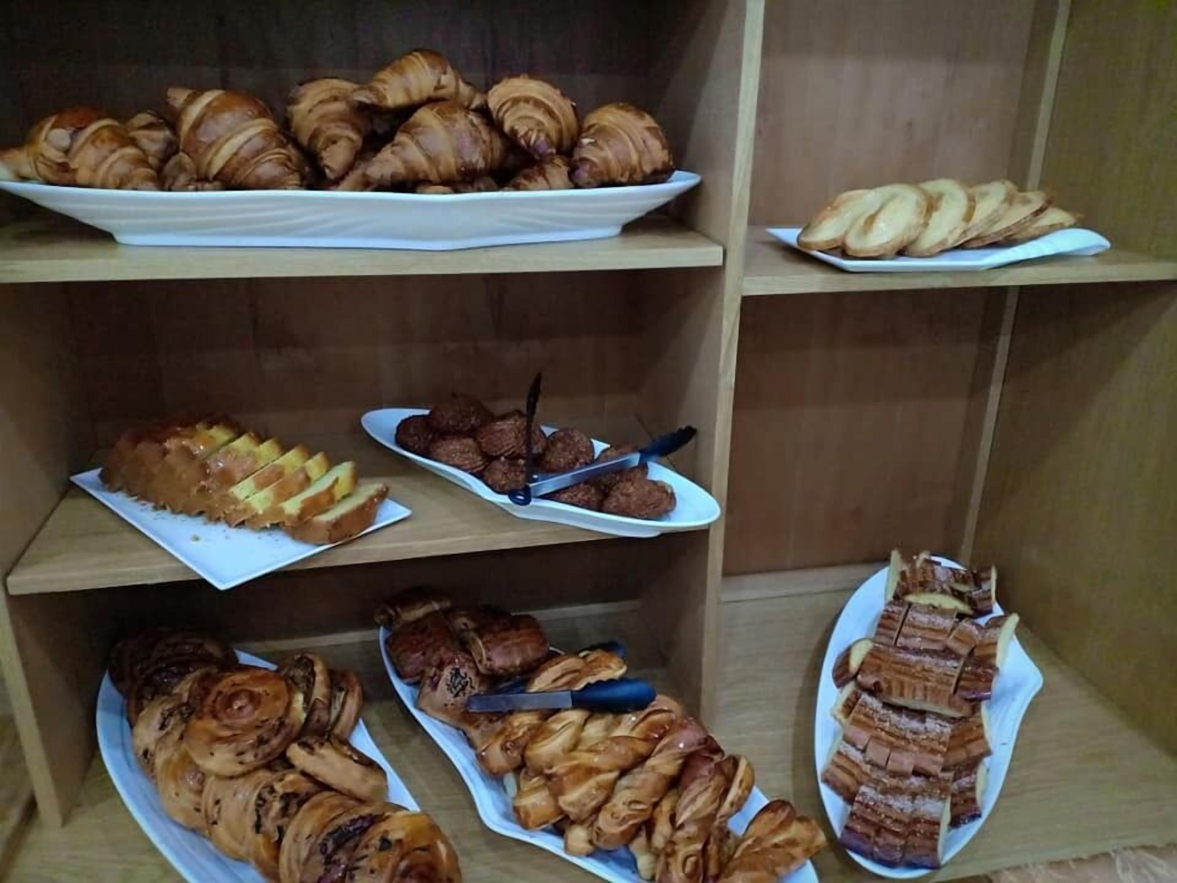 A display of various pastries and baked goods on shelves.