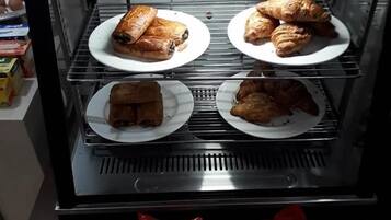 A bakery display case with pastries and bread.