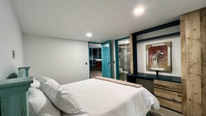 A bedroom with a bed, a wooden wardrobe, and a framed picture on the wall. - CLUB EL LLANO (Cómbita)