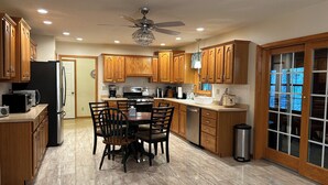 A modern kitchen with wooden cabinets, a dining table, and a ceiling fan. - RENEWING LICENSE: TEMPORARILY NO VACANCY- DO NOT AUTO BOOK3 BR Rambler Home - (Honesdale)