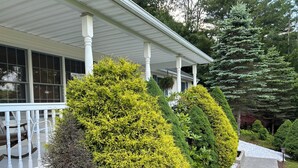 A house with a porch, white columns, and various well-maintained shrubs and trees. - RENEWING LICENSE: TEMPORARILY NO VACANCY- DO NOT AUTO BOOK3 BR Rambler Home - (Honesdale)