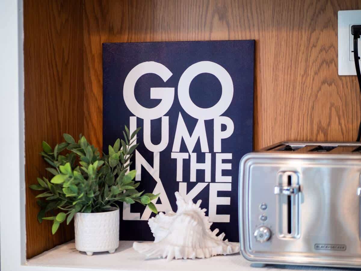 Una encimera de cocina con un tostador, una planta en maceta y un objeto decorativo.