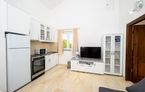A compact kitchen with a refrigerator, microwave, oven, and a coffee maker. - Gorgeous apartment in Komarna with WiFi (Komarna)