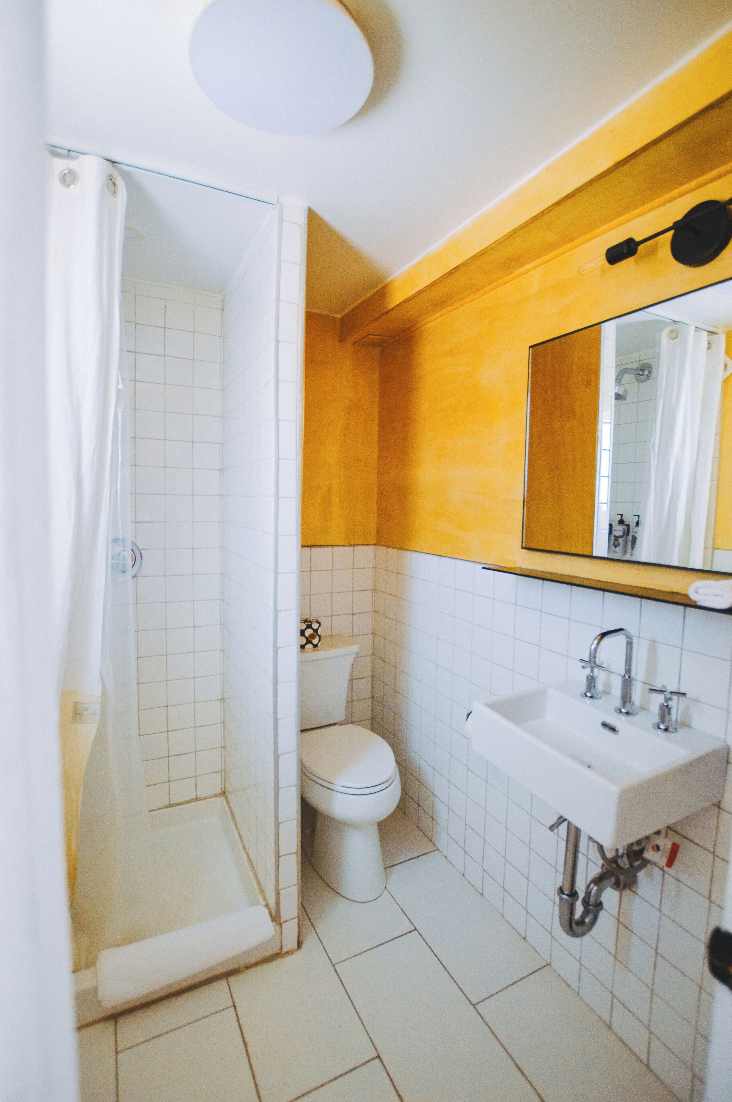 A bathroom with a shower, toilet, and sink.