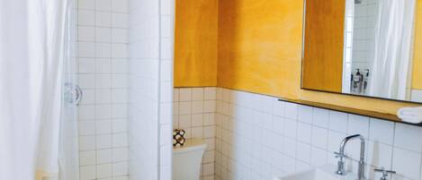 A bathroom with a shower, toilet, and sink.