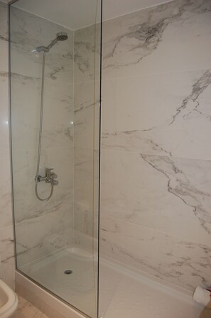 Een douche, een haardroger, een bidet, handdoeken