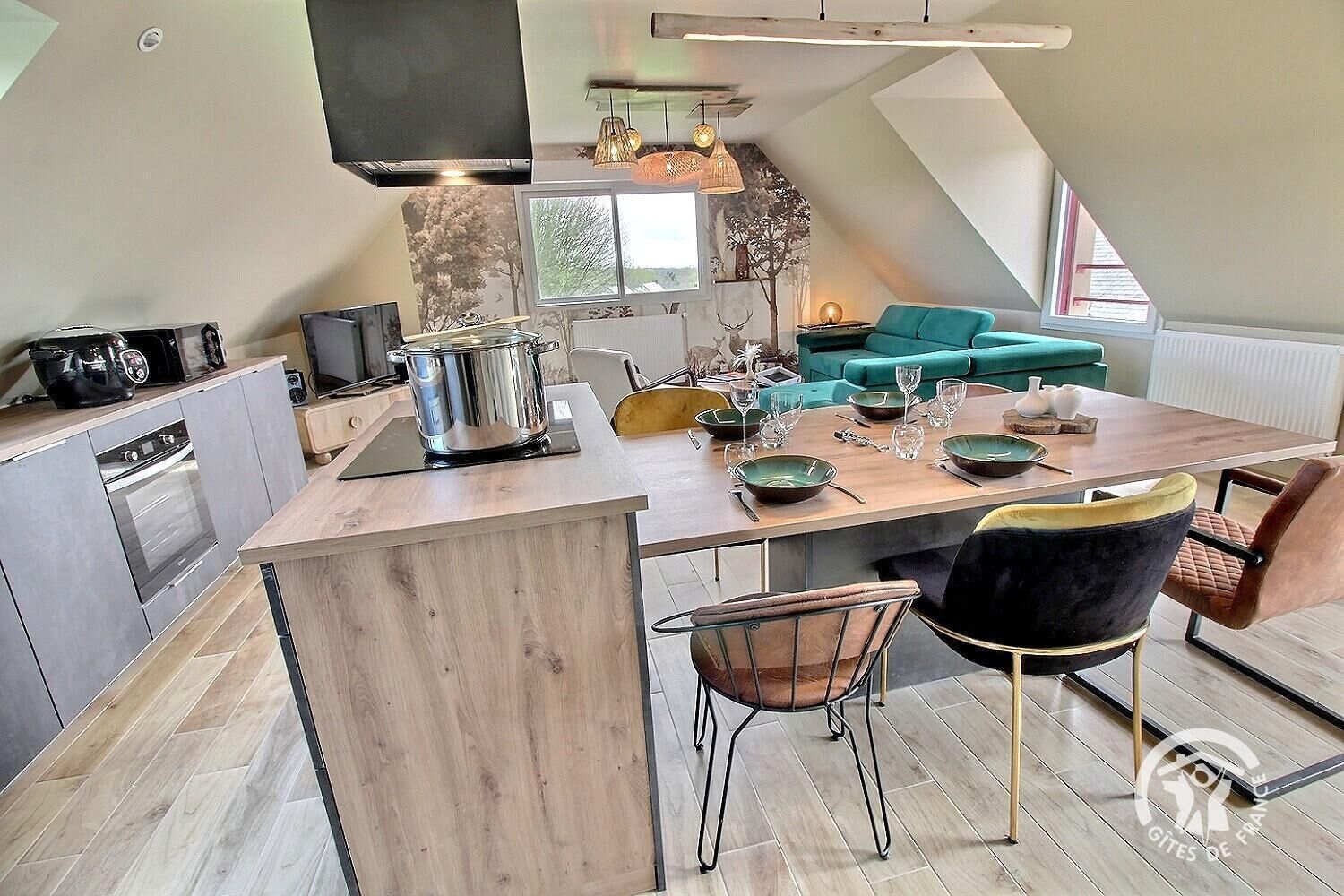 Un appartement moderne de style « loft » comprenant une cuisine, un coin repas et un espace de vie.