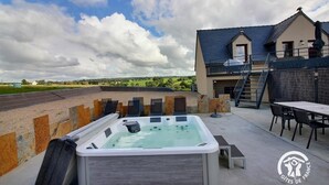 Un jacuzzi con vistas a una casa y al campo.