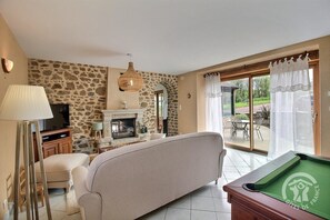 Télévision, cheminée, lecteur de DVD, livres