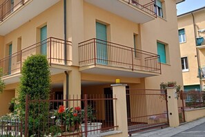 A multi-story residential building with balconies, a gated entrance, and potted plants. - SE069 - Senigallia, large four-room apartment convenient to services (Senigallia)