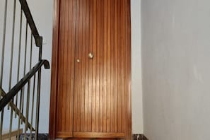 A wooden door with a brass handle and a keyhole, a metal handrail, and a tiled floor. - SE069 - Senigallia, large four-room apartment convenient to services (Senigallia)