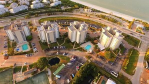 Vista aérea de una zona residencial costera con varios edificios altos, un puerto deportivo y una playa.