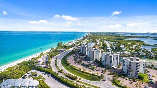 A coastal resort area with high-rise buildings, a beach, and a marina. - Luxury Beach Retreat Steps from Barefoot Beach & Restaurants (Bonita Springs)