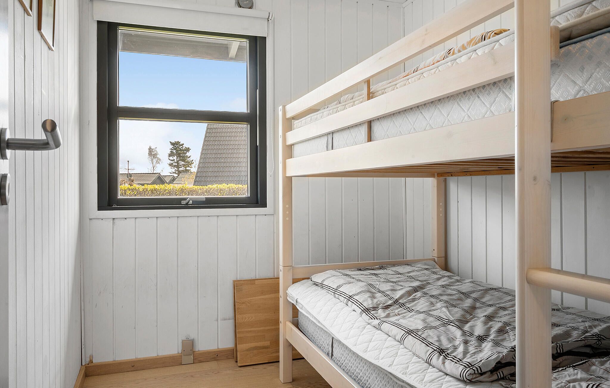 Ein Mehrbettzimmer mit einem Fenster mit Blick auf ein Feld.