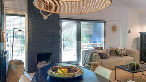 Un salon moderne avec une cheminée en pierre, une table à manger ronde et un canapé confortable.