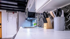 A kitchen with a marble countertop, a sink, and a knife block.