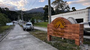 A sign for 'Residencial El Dorado' with a sun motif, a concrete pathway, a white pickup truck, and a mountainous backdrop. - Casa de Vacaciones (La ceiba)