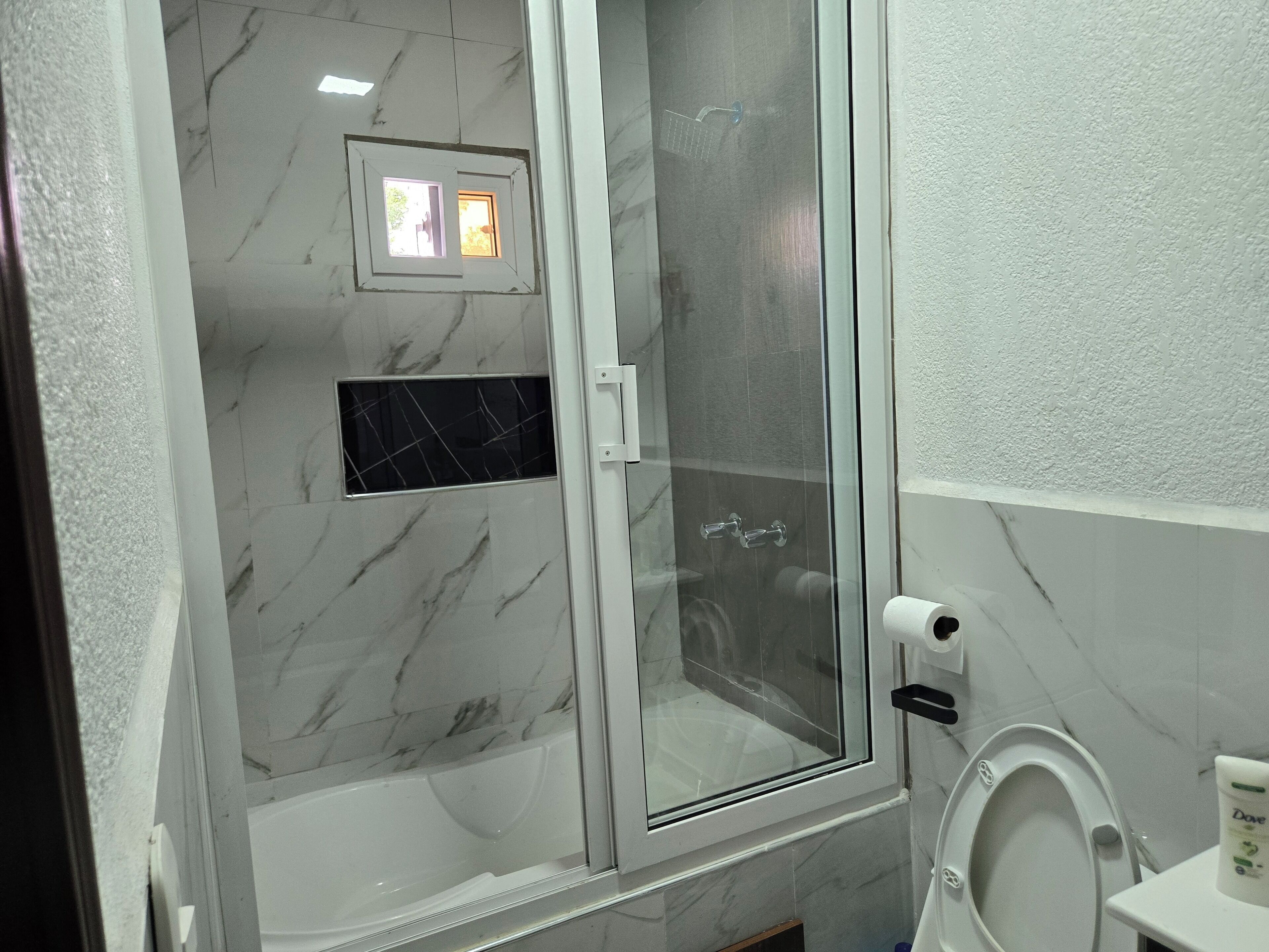 Een douche, handdoeken, zeep, shampoo