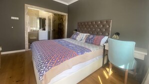 Une chambre à coucher avec un grand lit, une table de chevet, une chaise et une armoire.