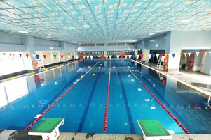 Una piscina con carriles de natación, bloques de salida y una silla de salvavidas.