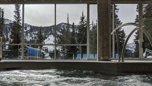 A pool with a view of snow-covered mountains and trees through large windows. - Snowbird's PREMIER Ski-in Ski-out Suite @ Iron Blosam Lodge (Snowbird)
