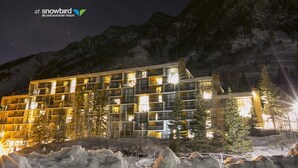 A multi-story hotel with a modern design, featuring balconies and large windows, set against a mountainous backdrop. - Snowbird's PREMIER Ski-in Ski-out Suite @ Iron Blosam Lodge (Snowbird)
